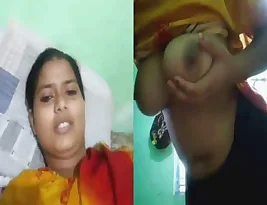 A woman from a Bengali village poses topless on camera.