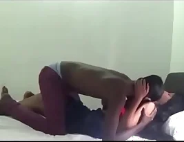 A black man and a white woman have sex in a hotel room and they do not know that there is a hidden camera.