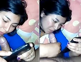 Beautiful woman takes self-portraits while performing oral sex on a man.